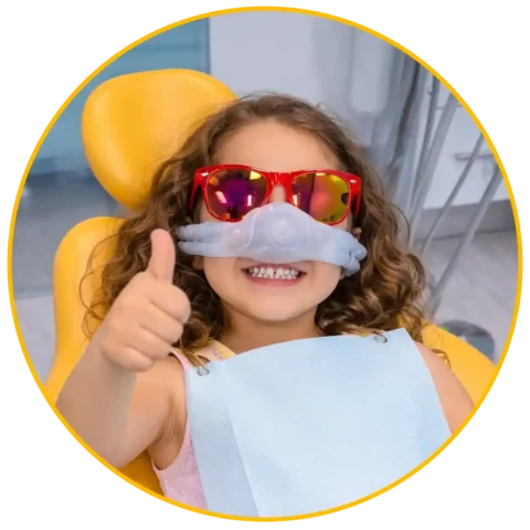 Child smiling during pediatric sedation dentistry with nitrous oxide mask at Hello Kids Dentistry in Pembroke Pines Florida